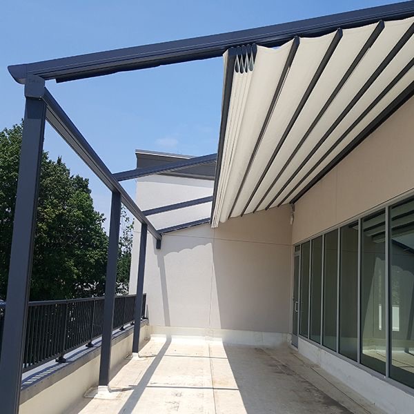 Terraza de departamento moderna con cierre de cristal plegable, amoblada con sofá. Terraza protegida del clima.