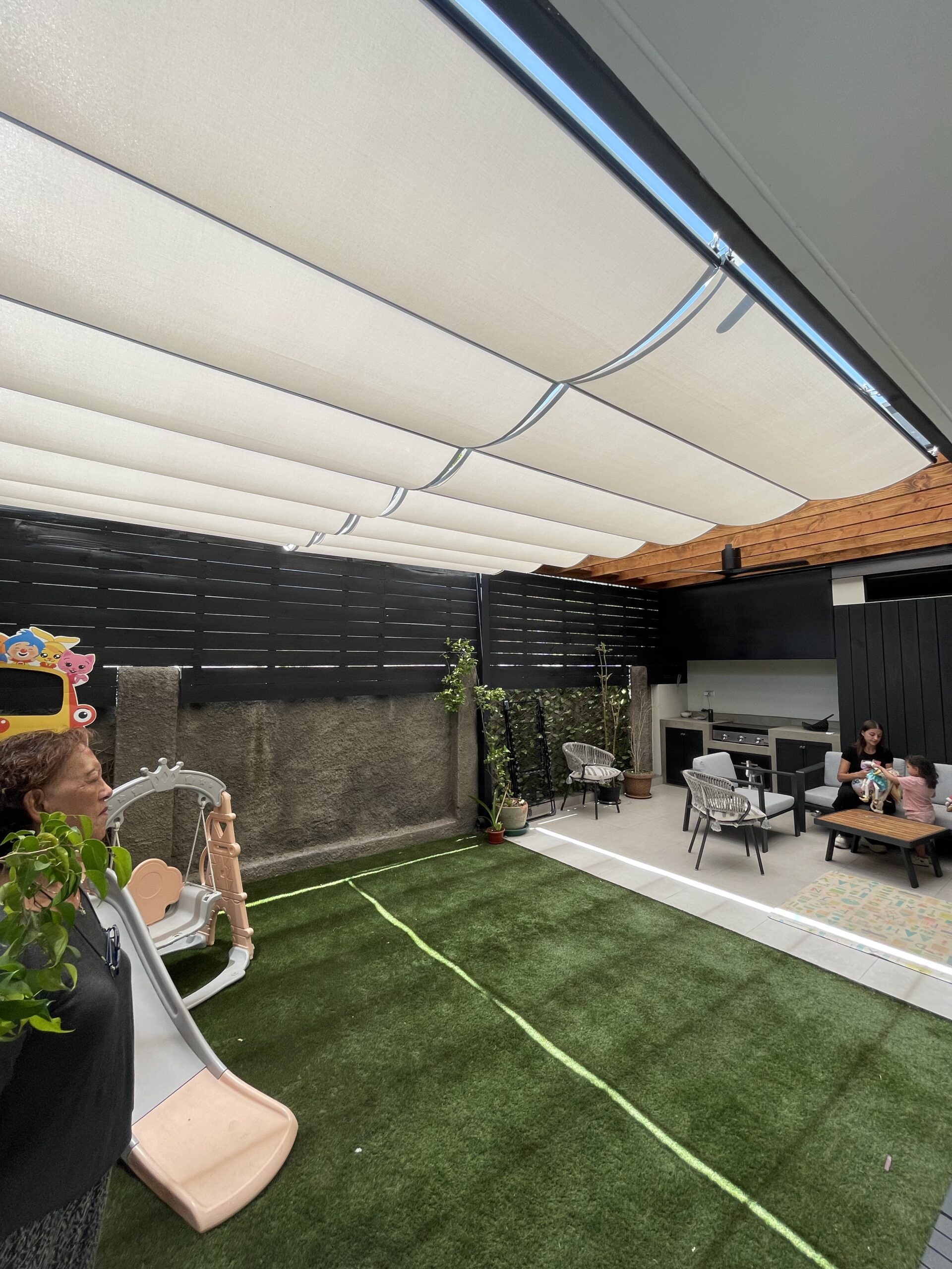 Terraza de departamento moderna con cierre de cristal plegable, amoblada con sofá. Terraza protegida del clima.