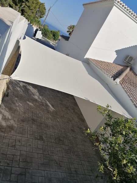 Terraza de departamento moderna con cierre de cristal plegable, amoblada con sofá. Terraza protegida del clima.