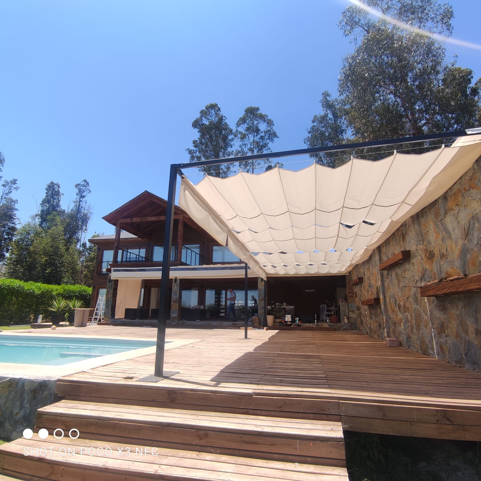 Terraza de departamento moderna con cierre de cristal plegable, amoblada con sofá. Terraza protegida del clima.